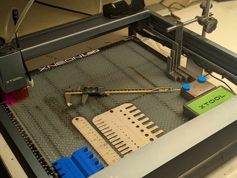 xTool laser engraver with material test pieces on the bed